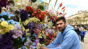 In Lviv, Ukrainians pause near memorial wall of flowers